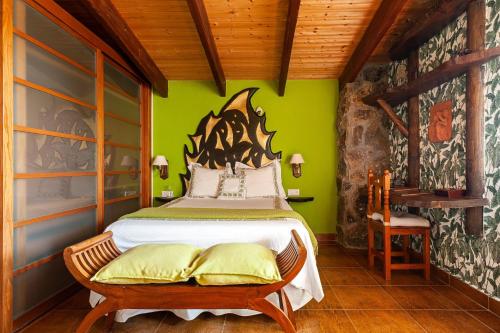 a bedroom with a bed and a green wall at Casa Balcón - Sólo Familias in Los Caños de Meca