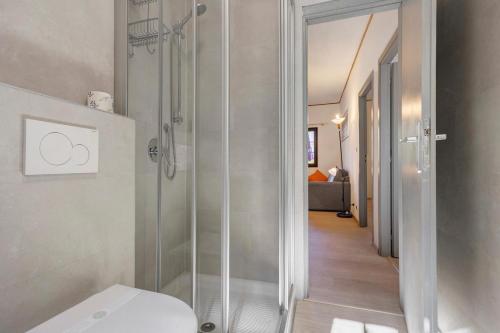 a bathroom with a shower with a toilet and a hallway at Casa Berthold in Ledro