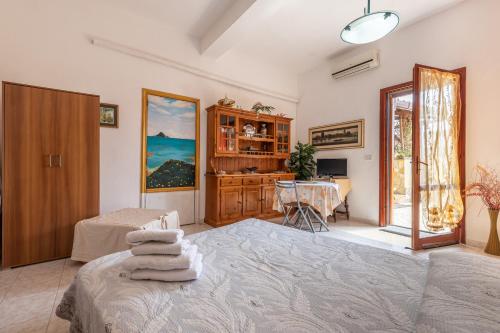 a bedroom with a bed and a desk with a table at Monolocale Il Girasole in Villaputzu