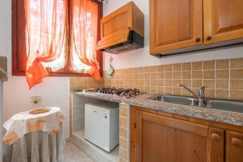 a small kitchen with a sink and a stove at Monolocale Il Girasole in Villaputzu