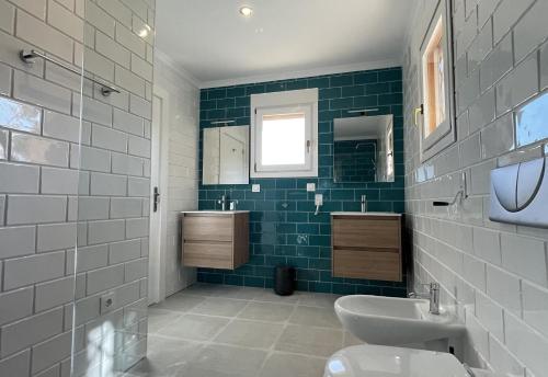 a bathroom with a sink and a toilet and green tiles at Gloriann in Moraira