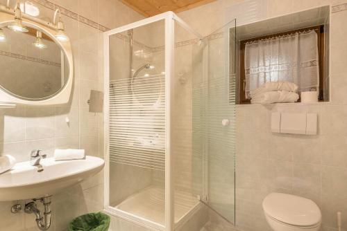 a bathroom with a shower and a toilet and a sink at Sabina Dolomites Euringer in Alpe di Siusi
