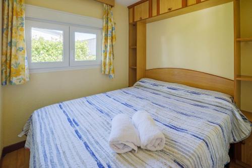 a bedroom with a bed with towels on it at Bungalow B1 in Pontevedra