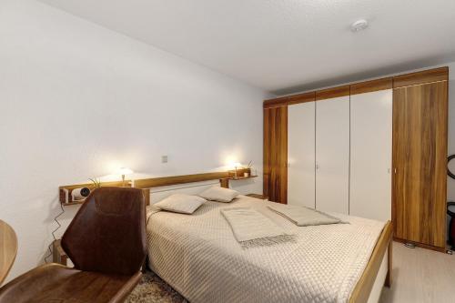 a bedroom with a bed and a chair in it at eva Ferienwohnung in Engen