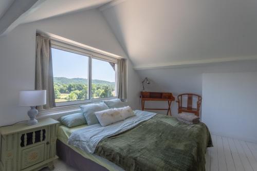 a bedroom with a bed and a large window at Peaceful Countryside Getaway in Parbayse