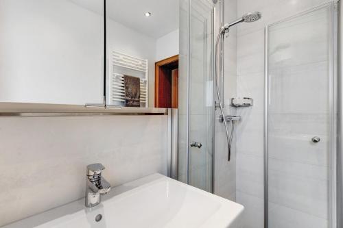 a white bathroom with a sink and a shower at Ferienwohnung Blumenau in Schmallenberg