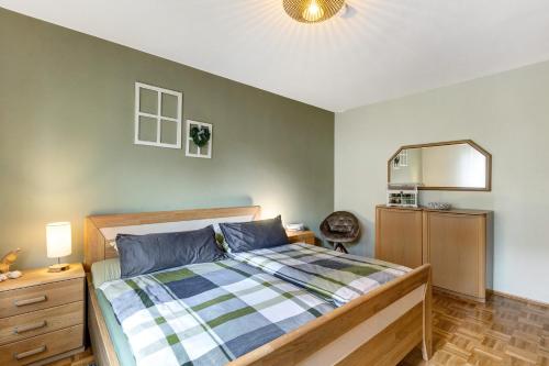 a bedroom with a bed and a dresser and a mirror at Ferienwohnung Blumenau in Schmallenberg