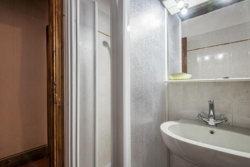 a white bathroom with a sink and a mirror at Casale Rosennano - Loggia in Rosennano
