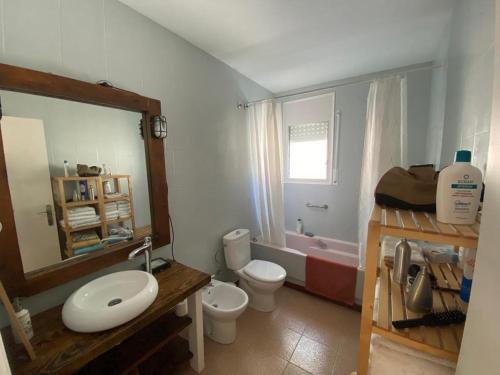 a bathroom with a sink and a toilet and a tub at Lola's Beach House in Calafell