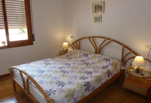 a bed in a bedroom with two lamps on tables at El Castillito in Begur