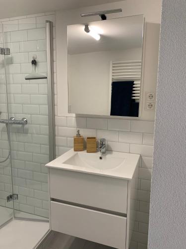 a white bathroom with a sink and a mirror at Fewo im schönen Allensbach in Allensbach