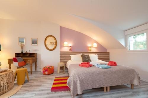 a bedroom with a bed and a desk in a room at Côté Vannes in Ploeren