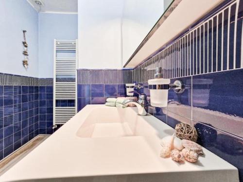 a bathroom with a white sink and blue tiles at Villa Galatea Stella Marina in Capoliveri