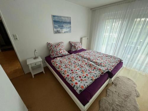 a bedroom with a bed and a nightstand with a window at Lerchenglück in Lottstetten