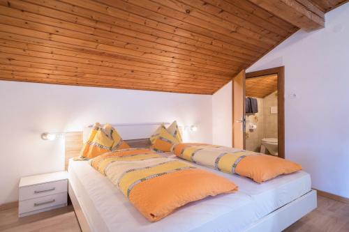 a bedroom with a bed with orange pillows at Apartment Tschigat Leilichhof in Lana