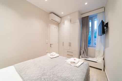 a white bedroom with a bed and a window at Seawind Gouvia in Corfu