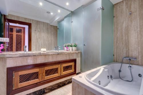 a bathroom with a large tub and a large mirror at Exclusive frontline beach penthouse in Estepona