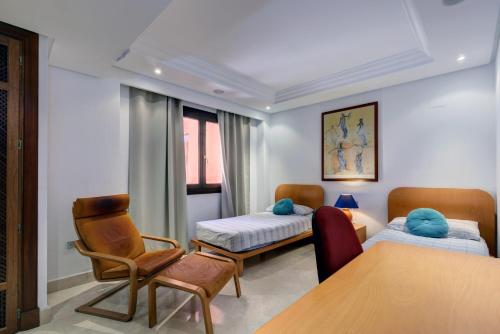 a room with two beds and a table and chairs at Exclusive frontline beach penthouse in Estepona