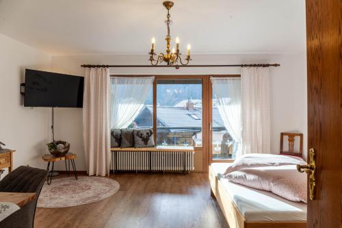 a bedroom with a bed and a large window at Aschaubichl - Wohnung Bergaurikel in Grainau