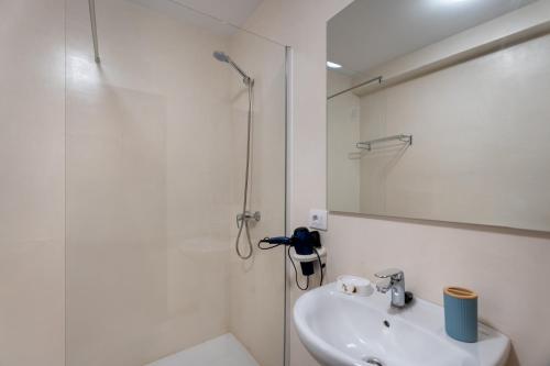 a white bathroom with a shower and a sink at Las Flores 1D in Costa de Adeje