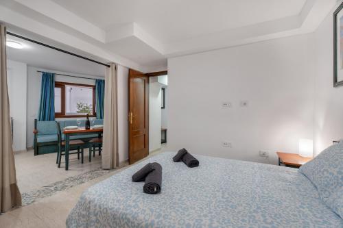 a bedroom with a bed with slippers on top of it at Las Flores 1D in Costa de Adeje