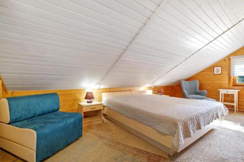a bedroom with a bed and a couch and a chair at Haus Wildgans in Lychen