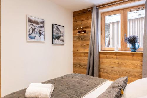 a bedroom with a bed and a window at Lodge Alouette in Champagny-en-Vanoise