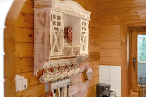 a kitchen with wooden walls and a cabinet and utensils at Haus Wildgans in Lychen