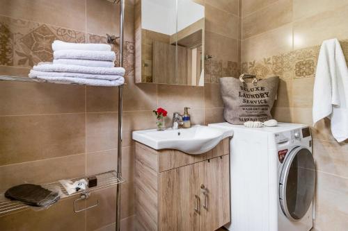 a bathroom with a sink and a washing machine at Lefkada view villa Vasiliki 1 in Peratiá