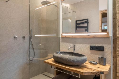 a bathroom with a sink and a glass shower at Chalet Kasch Apartment Berg in Völs am Schlern