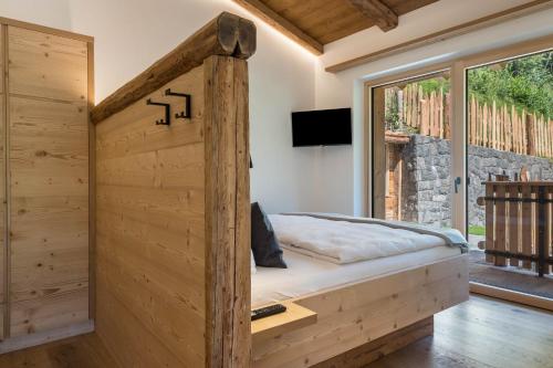 a wooden bed in a room with a window at Chalet Kasch Apartment Berg in Völs am Schlern