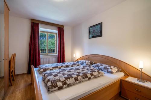 a bedroom with a bed and a window at Ferienwohnung Brunjaunhof in Schenna