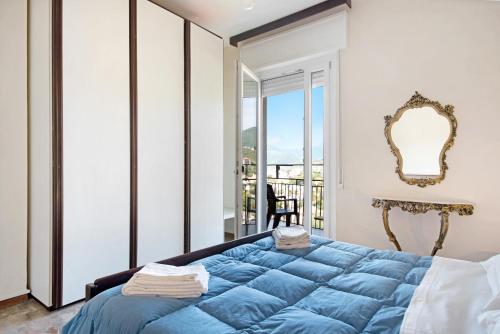 a bedroom with a blue bed and a balcony at Condominio Sereno in Rapallo