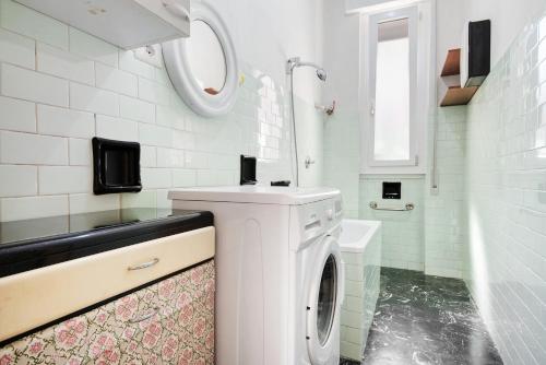 a white bathroom with a washing machine and a sink at Condominio Sereno in Rapallo