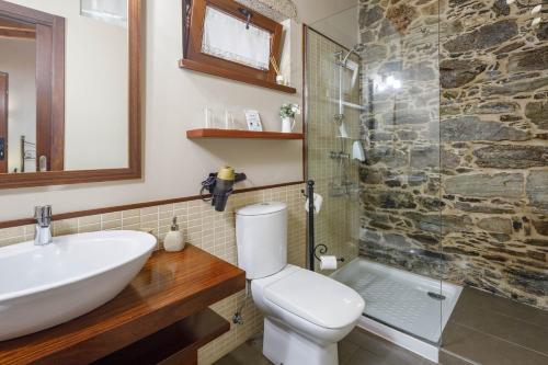 a bathroom with a sink and a toilet and a shower at O Pozo in Ordes