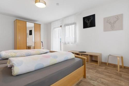 a bedroom with two beds and a table in it at Ferienhof Brutoni in Bad Peterstal-Griesbach