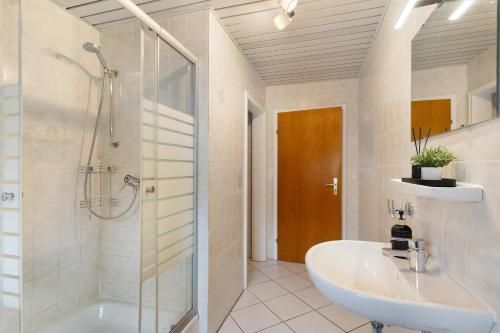 a bathroom with a shower and a sink and a tub at Ferienhof Brutoni in Bad Peterstal-Griesbach