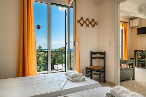 a bedroom with a bed and a large window at Anemona apartment 1 in Kefallonia