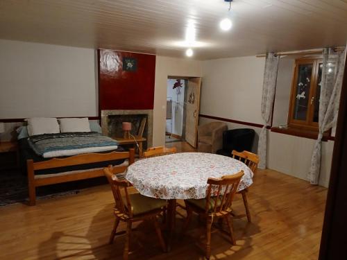 a room with a table and chairs and a bed at Ancienne petite ferme in Châtelblanc