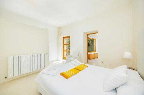a white bedroom with a bed and a window at Casa Con Piscina En Selva in El Port de la Selva