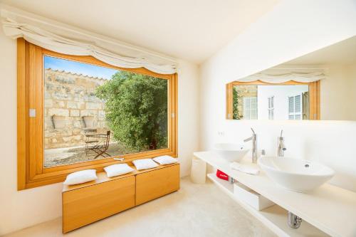 a bathroom with two sinks and a large window at Casa Con Piscina En Selva in El Port de la Selva