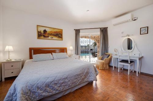 a bedroom with a bed and a desk and a table at Brisa do Mar in Carvoeiro