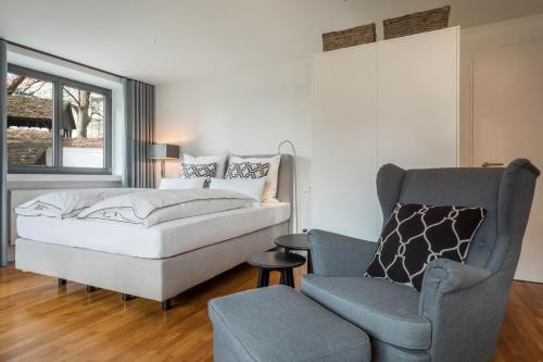 a bedroom with a bed and a chair and a couch at 1 Zimmer-appartment Nr 12 in Wangen im Allgäu