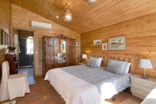 a bedroom with a bed in a room with wooden walls at Cabana Gardenhouse in Loulé