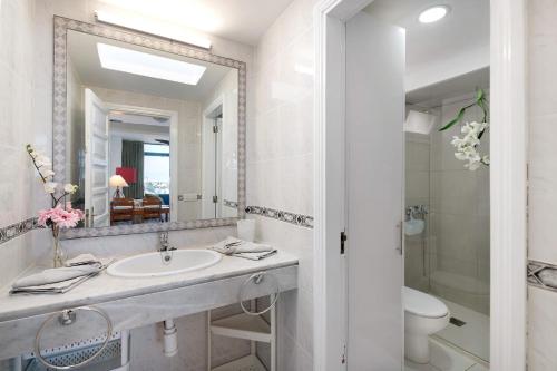 a bathroom with a sink and a toilet and a mirror at Los Molinos 4306 in Costa Teguise