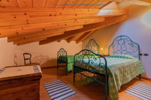 a bedroom with a bed in a room with wooden ceilings at Villa Archi in Colico
