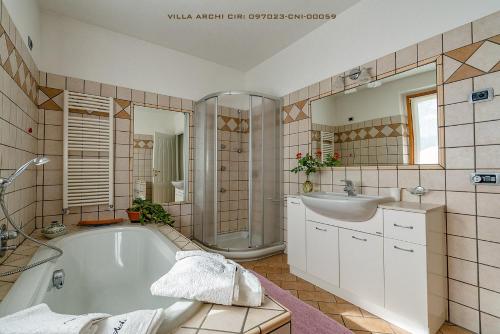 a bathroom with a tub and a sink at Villa Archi in Colico