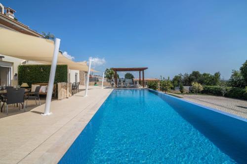 a swimming pool with blue water in a house at Cabana Gardenhouse in Loulé