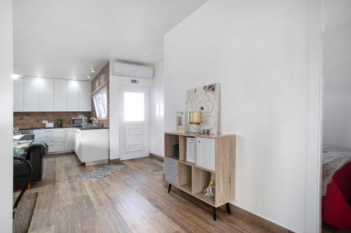 a small kitchen with white walls and wooden floors at Casa da Padaria in Leiria