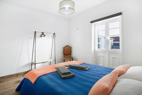 a bedroom with a bed with two towels on it at Casa da Padaria in Leiria